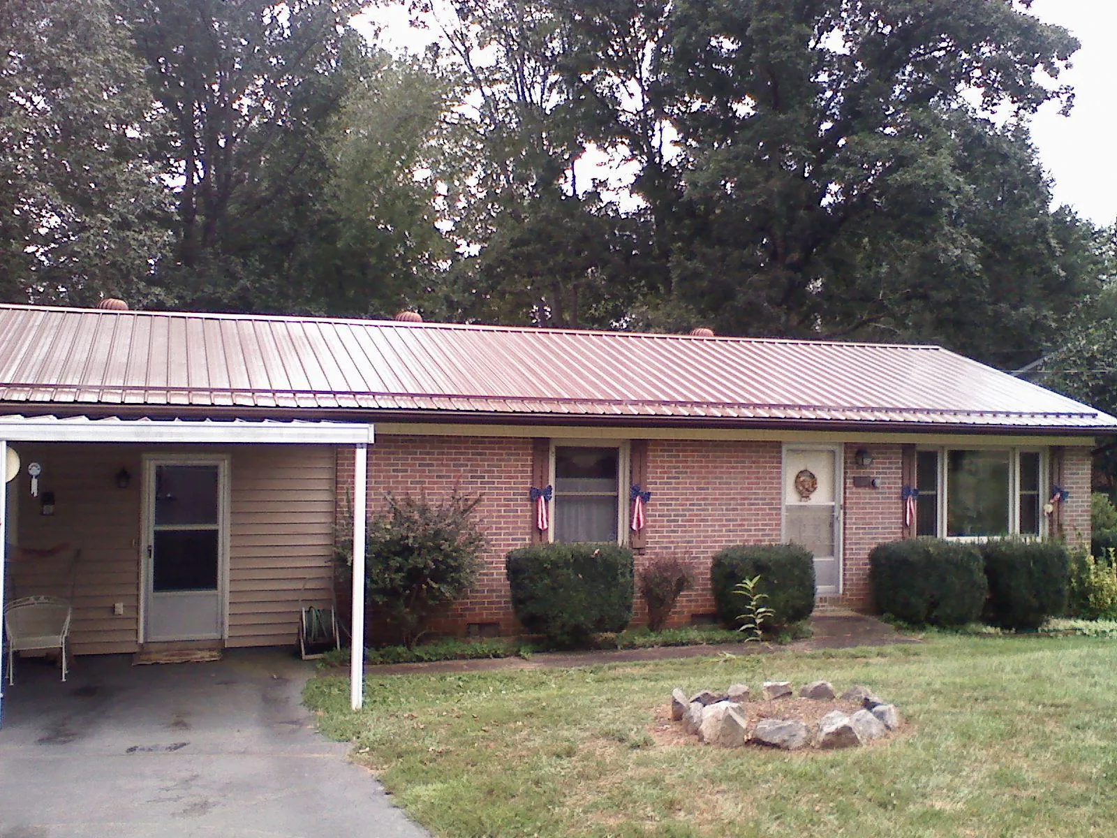 Bronze metal roof and carport on a brick ranch home — Roof Repair work by our crew in Fayetteville